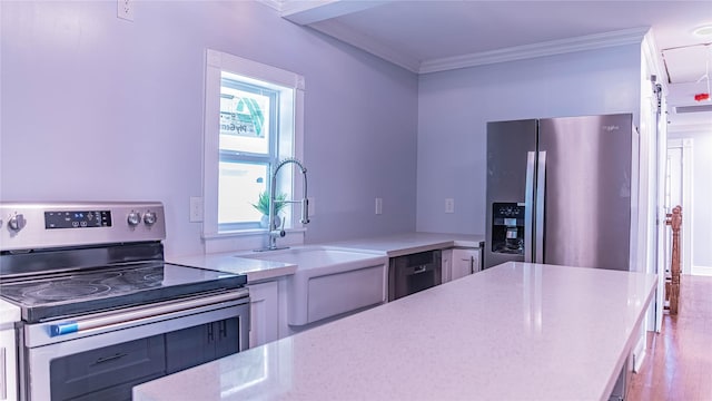 6201 Heards Ln, Galveston, TX 77551 - kitchen with stainless steel appliances, crown molding, and wood finished floors