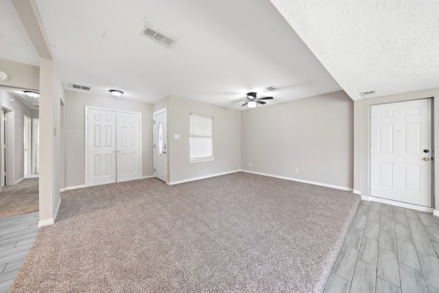 7421 Parker Rd, Houston, TX 77016 - unfurnished living room featuring a ceiling fan, light wood-style flooring, and light colored carpet