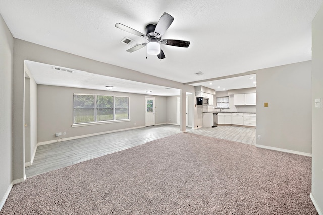 7421 Parker Rd, Houston, TX 77016 - unfurnished living room featuring light colored carpet, ceiling fan, recessed lighting, and a textured ceiling