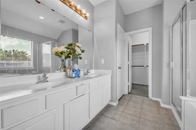 20607 Dademount Ct, Richmond, TX 77407 - bathroom with a stall shower, double vanity, tile patterned floors, and a walk in closet