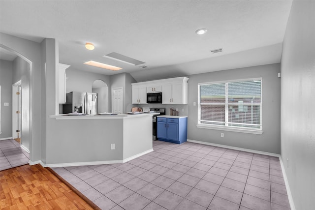 20607 Dademount Ct, Richmond, TX 77407 - kitchen with appliances with stainless steel finishes, white cabinets, light countertops, blue cabinets, and light tile patterned floors