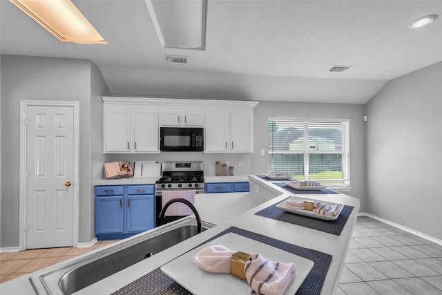 20607 Dademount Ct, Richmond, TX 77407 - kitchen featuring black microwave, stainless steel gas stove, white cabinetry, light tile patterned floors, and lofted ceiling