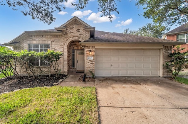 20607 Dademount Ct, Richmond, TX 77407 - view of front facade with concrete driveway, a garage, brick siding, and roof with shingles
