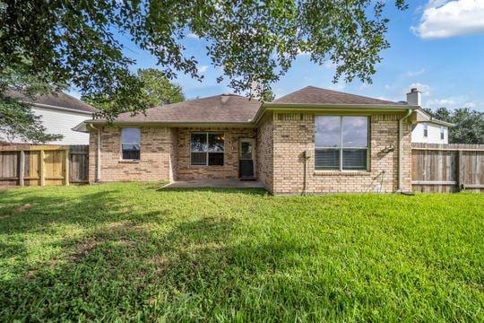 20607 Dademount Ct, Richmond, TX 77407 - back of property featuring a fenced backyard, a chimney, and brick siding
