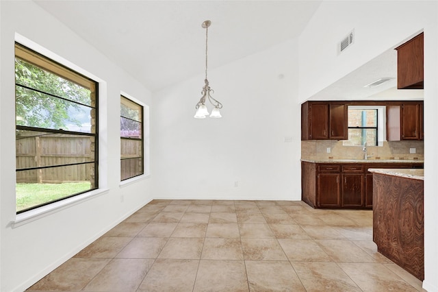 2730 Mesquite Dr, Sugar Land, TX 77479 - kitchen with backsplash, decorative light fixtures, light stone countertops, lofted ceiling, and light tile patterned flooring