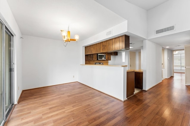 14555 Wunderlich Dr Unit 2602, Houston, TX 77069 - kitchen featuring stainless steel microwave, light wood-style flooring, a peninsula, and light countertops