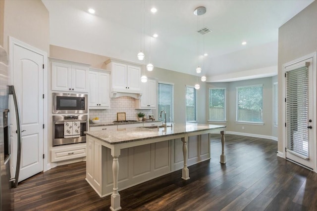 23 N Wheatleigh Dr, Tomball, TX 77375 - kitchen with stainless steel appliances, dark wood-style flooring, tasteful backsplash, light stone counters, and a kitchen bar