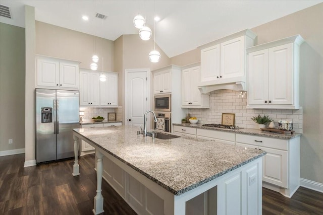 23 N Wheatleigh Dr, Tomball, TX 77375 - kitchen featuring stainless steel appliances, dark wood-style flooring, an island with sink, white cabinets, and decorative backsplash