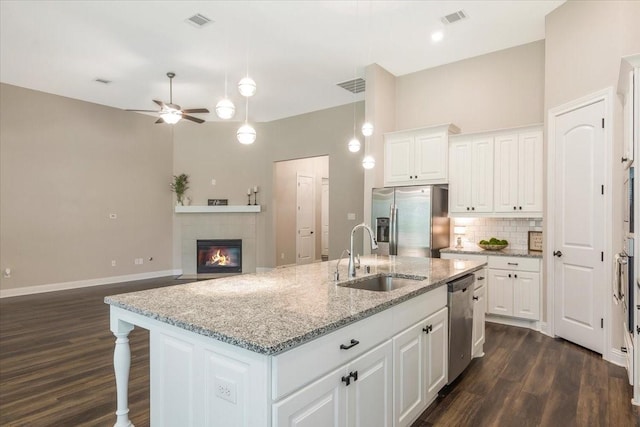 23 N Wheatleigh Dr, Tomball, TX 77375 - kitchen with stainless steel appliances, dark wood finished floors, a ceiling fan, and tasteful backsplash