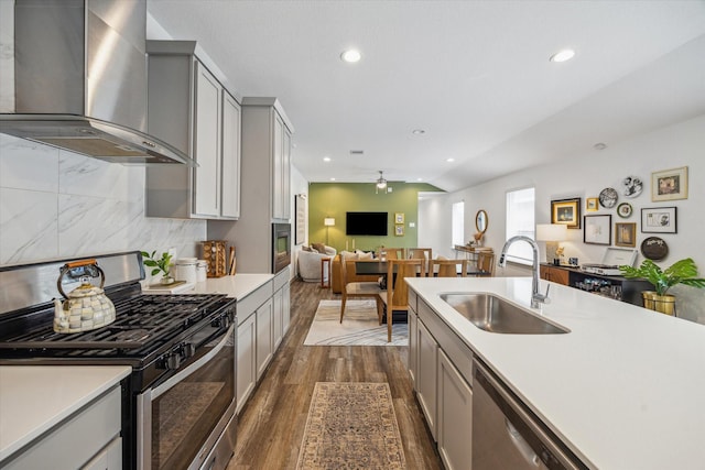 12717 Ermine St, Houston, TX 77047 - kitchen featuring appliances with stainless steel finishes, wall chimney exhaust hood, gray cabinetry, light countertops, and recessed lighting