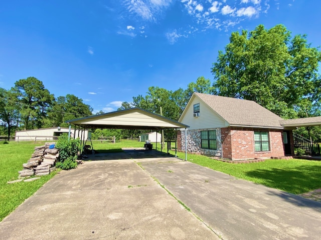 328 Mcguire Rd, Lufkin, TX 75901 - view of side of home with a carport, a lawn, driveway, brick siding, and roof with shingles