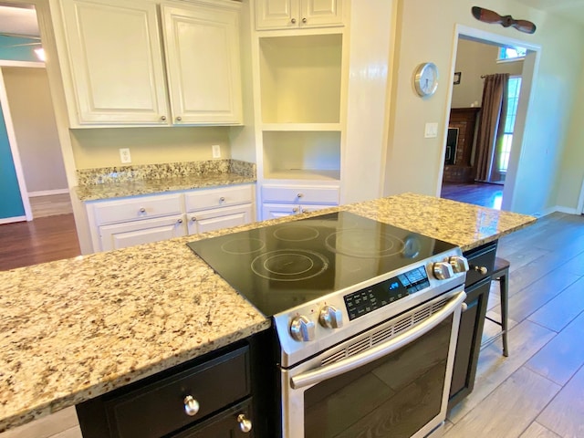 328 Mcguire Rd, Lufkin, TX 75901 - kitchen with stainless steel range with electric stovetop, light wood finished floors, and light stone countertops
