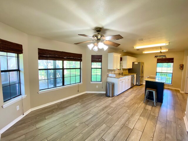 328 Mcguire Rd, Lufkin, TX 75901 - kitchen featuring appliances with stainless steel finishes, white cabinets, light wood-style floors, and ceiling fan