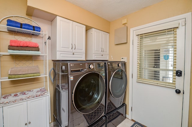 22410 Bucktrout Ln, Katy, TX 77449 - laundry area with washer and clothes dryer, cabinet space, light tile patterned floors, and a textured ceiling