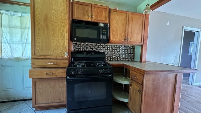 7338 Hurtgen Forest Rd, Houston, TX 77033 - kitchen featuring black appliances, decorative backsplash, brown cabinetry, and built in desk