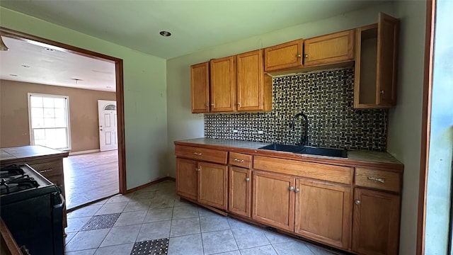 7338 Hurtgen Forest Rd, Houston, TX 77033 - kitchen with range with gas stovetop, tile countertops, and backsplash