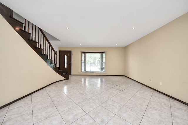 7655 Bellerive Dr Unit 3, Houston, TX 77036 - unfurnished living room featuring light tile patterned floors, stairway, and recessed lighting