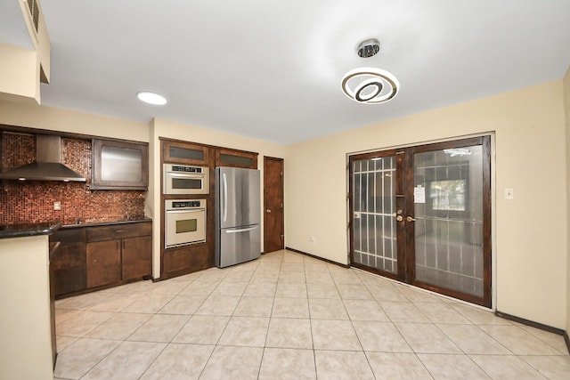 7655 Bellerive Dr Unit 3, Houston, TX 77036 - kitchen featuring appliances with stainless steel finishes, wall chimney exhaust hood, dark countertops, tasteful backsplash, and light tile patterned flooring