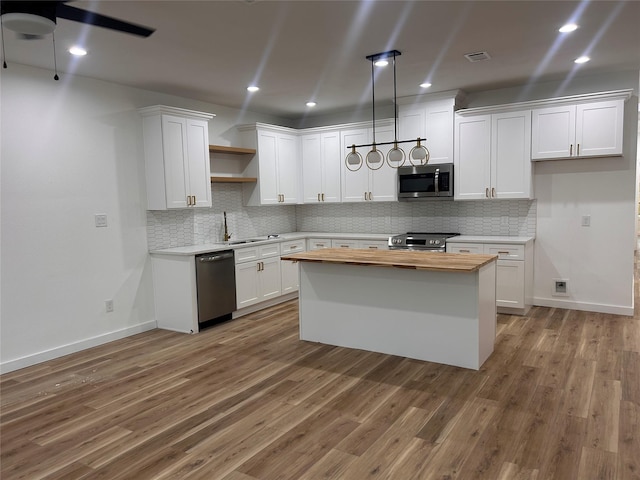 6206 Lyndhurst Dr, Houston, TX 77087 - kitchen with appliances with stainless steel finishes, butcher block countertops, open shelves, light wood-style flooring, and white cabinetry