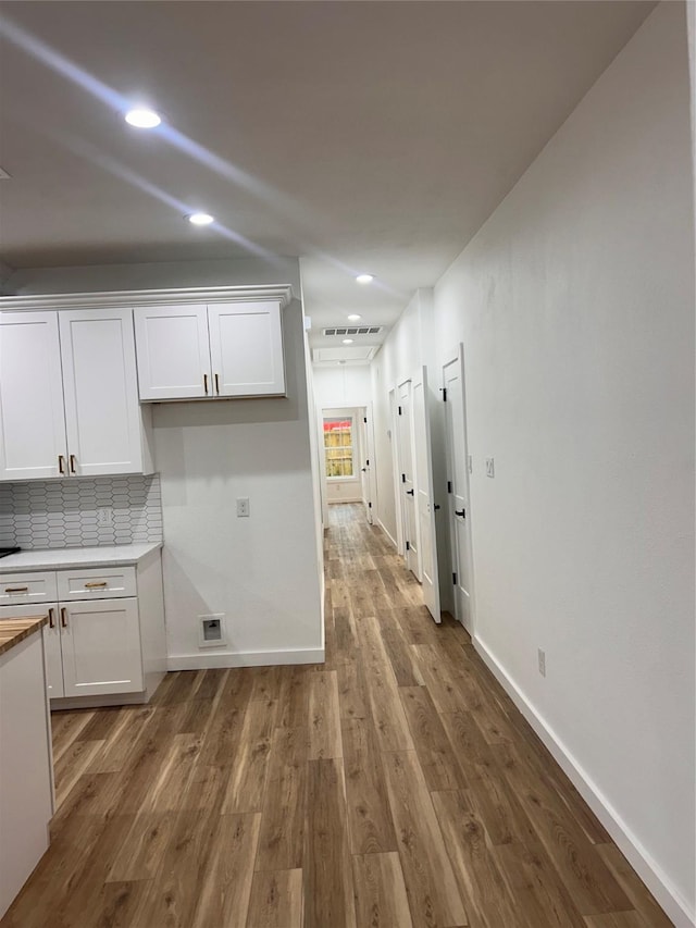 6206 Lyndhurst Dr, Houston, TX 77087 - kitchen featuring white cabinets, wood finished floors, light countertops, recessed lighting, and decorative backsplash