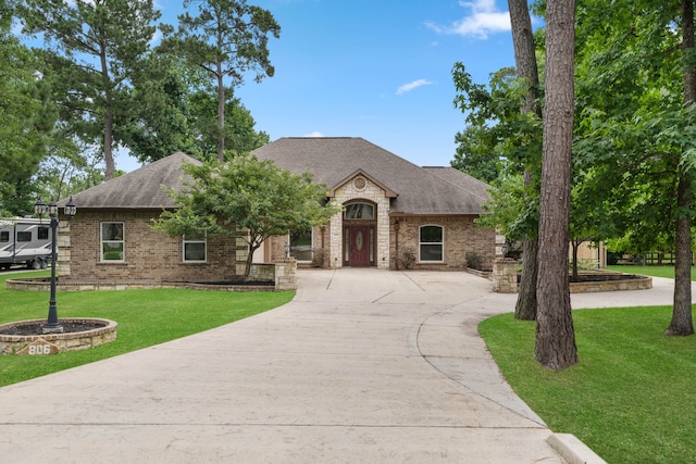 806 Garrett Dr, Magnolia, TX 77354 - french provincial home featuring a shingled roof, brick siding, and concrete driveway
