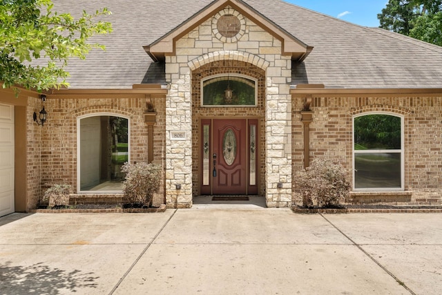 806 Garrett Dr, Magnolia, TX 77354 - property entrance featuring a shingled roof, brick siding, and stone siding