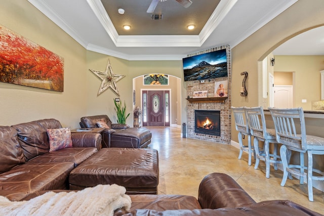 806 Garrett Dr, Magnolia, TX 77354 - tiled living area with arched walkways, a raised ceiling, ceiling fan, a brick fireplace, and crown molding