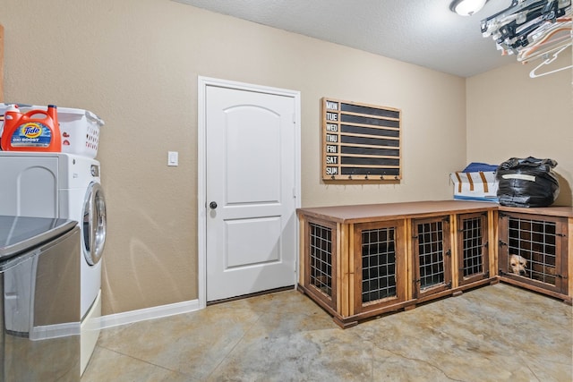 806 Garrett Dr, Magnolia, TX 77354 - laundry area featuring washing machine and clothes dryer and a textured ceiling