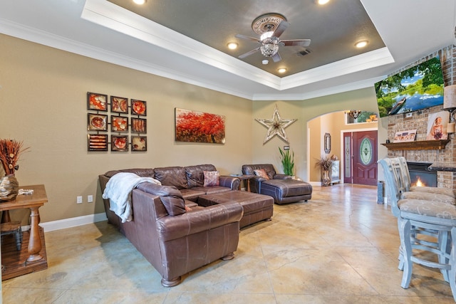806 Garrett Dr, Magnolia, TX 77354 - living area with a tray ceiling, arched walkways, ceiling fan, ornamental molding, and a large fireplace