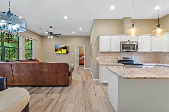 806 Garrett Dr, Magnolia, TX 77354 - kitchen with stainless steel appliances, open floor plan, white cabinets, light wood-type flooring, and backsplash