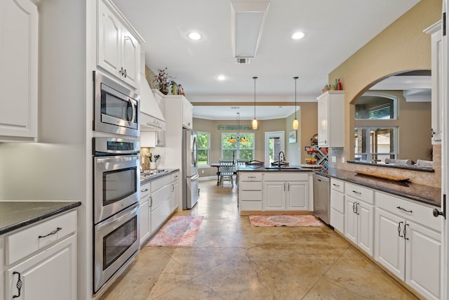 806 Garrett Dr, Magnolia, TX 77354 - kitchen featuring appliances with stainless steel finishes, recessed lighting, arched walkways, and white cabinets