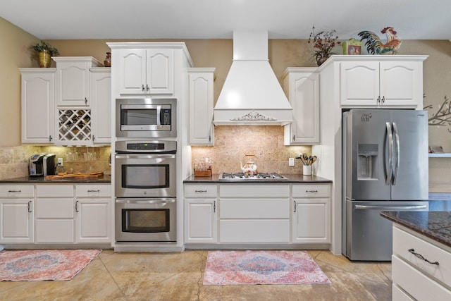 806 Garrett Dr, Magnolia, TX 77354 - kitchen featuring appliances with stainless steel finishes, custom exhaust hood, and white cabinets