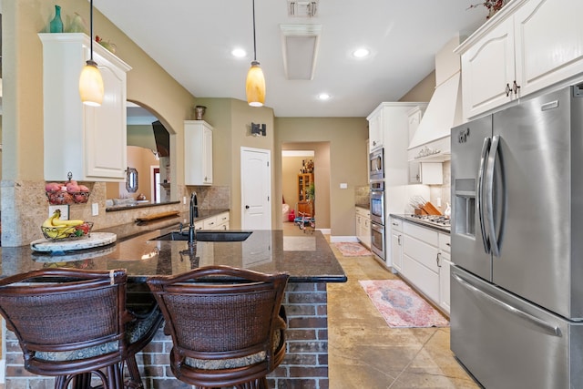 806 Garrett Dr, Magnolia, TX 77354 - kitchen featuring stainless steel appliances, decorative backsplash, white cabinetry, custom exhaust hood, and a kitchen bar