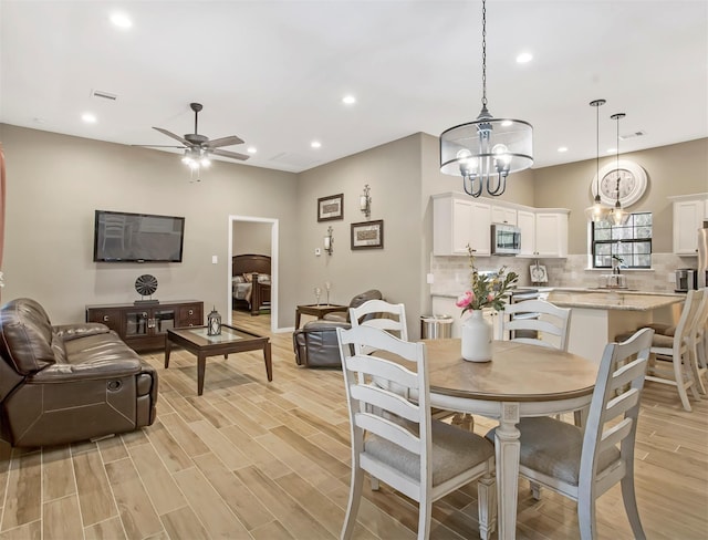 806 Garrett Dr, Magnolia, TX 77354 - dining space featuring recessed lighting, a ceiling fan, light wood-type flooring, and a chandelier