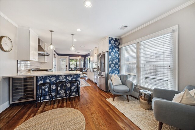 1014 E 25th St, Houston, TX 77009 - kitchen with wine cooler, wall chimney range hood, white cabinetry, stainless steel fridge, and dark wood-style flooring