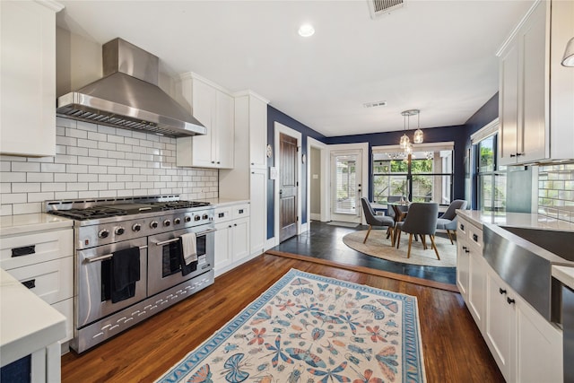 1014 E 25th St, Houston, TX 77009 - kitchen featuring double oven range, wall chimney range hood, light countertops, white cabinetry, and recessed lighting