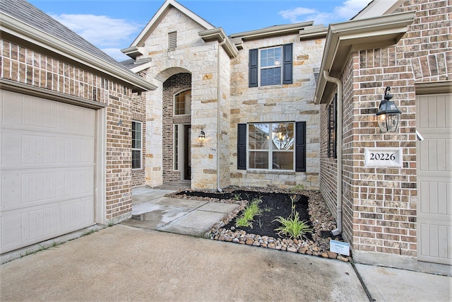 20226 Overland Hills Ln, Cypress, TX 77433 - doorway to property featuring stone siding and a garage