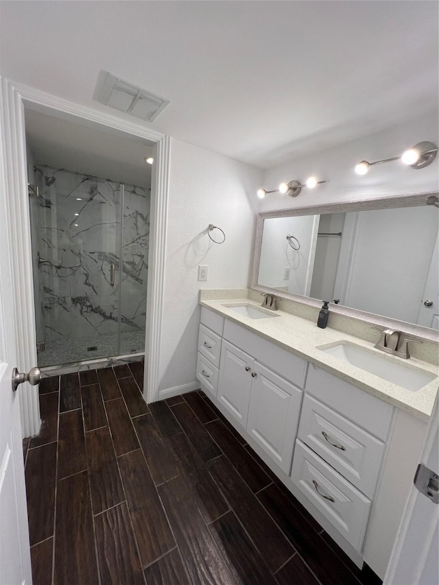 2372 Woodland Park Dr Unit 121, Houston, TX 77077 - full bathroom with double vanity, a marble finish shower, and wood finish floors