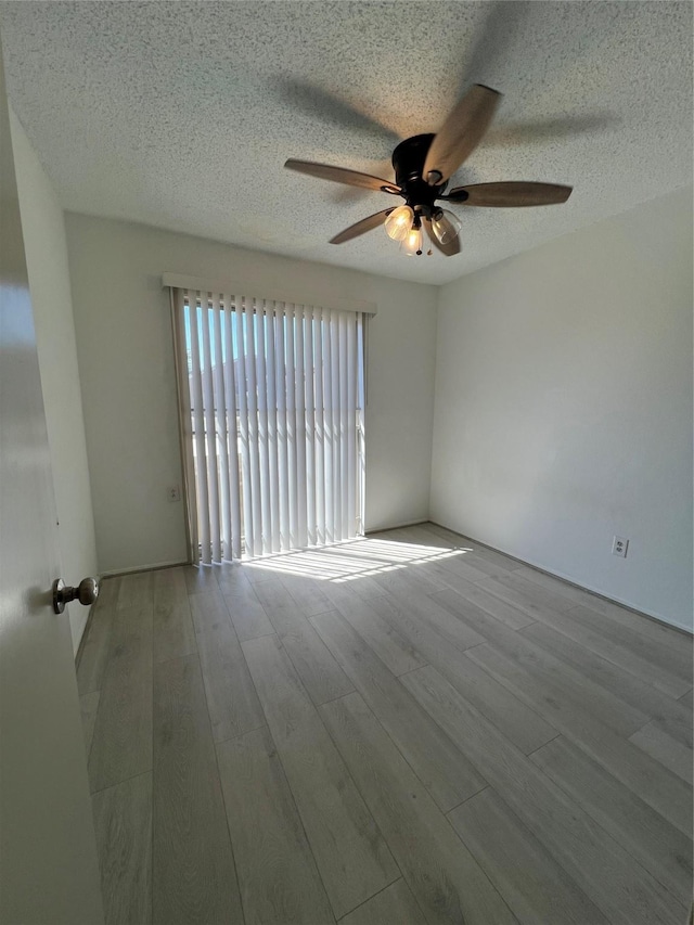 2372 Woodland Park Dr Unit 121, Houston, TX 77077 - empty room with a ceiling fan, wood finished floors, and a textured ceiling