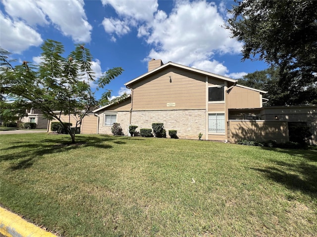 2372 Woodland Park Dr Unit 121, Houston, TX 77077 - view of home's exterior featuring a chimney and a lawn