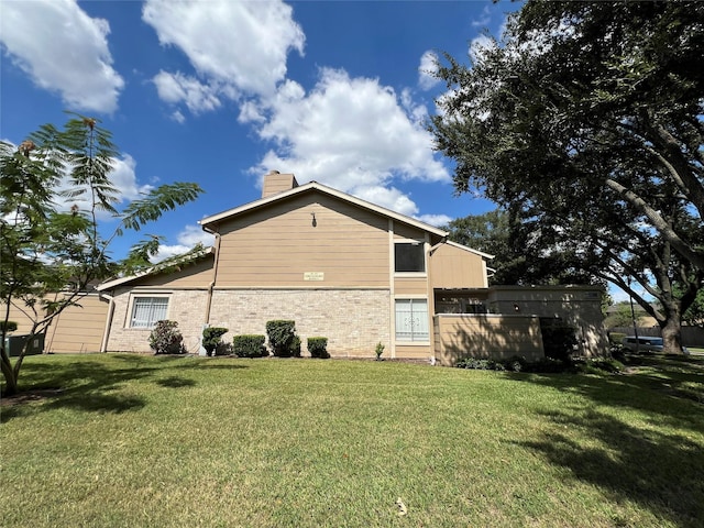 2372 Woodland Park Dr Unit 121, Houston, TX 77077 - view of property exterior featuring a chimney, a lawn, and brick siding