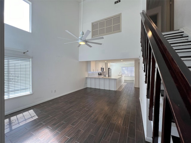 2372 Woodland Park Dr Unit 121, Houston, TX 77077 - unfurnished living room with a towering ceiling, ceiling fan, dark wood-style floors, and stairway