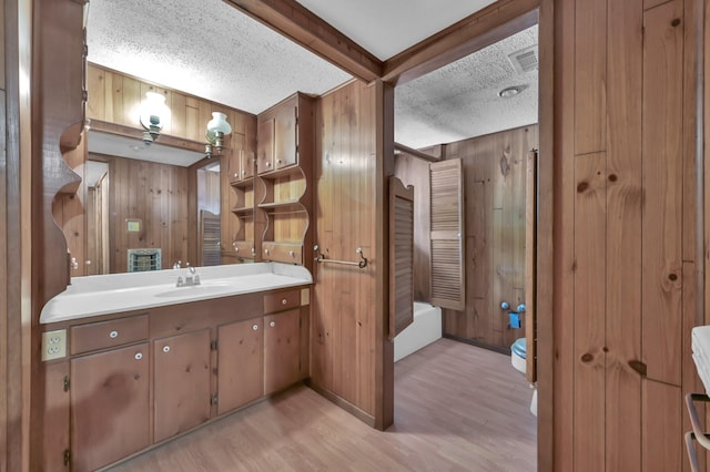 17230 Pioneer Trl, Conroe, TX 77302 - full bath with wooden walls, vanity, wood finished floors, a textured ceiling, and beam ceiling