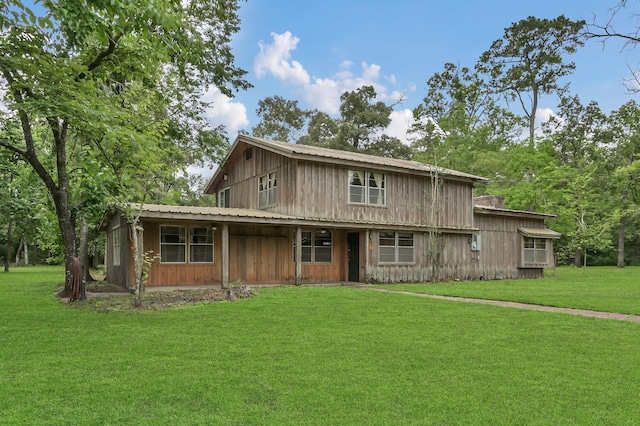 17230 Pioneer Trl, Conroe, TX 77302 - view of front facade with a front yard, board and batten siding, a metal roof, and covered porch