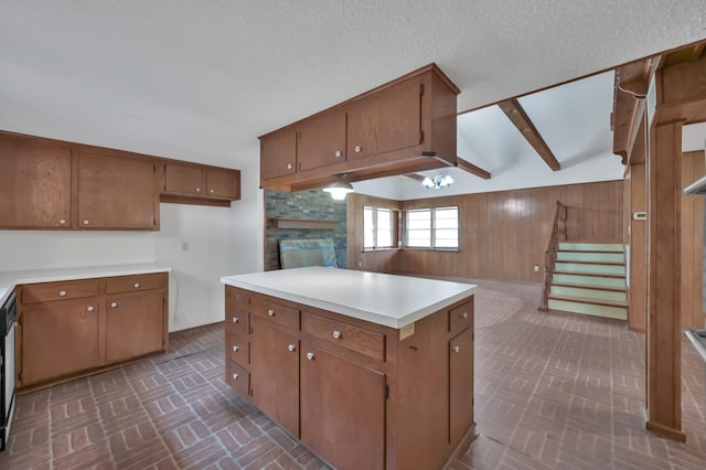 17230 Pioneer Trl, Conroe, TX 77302 - kitchen featuring brick patterned floors, brown cabinets, a fireplace, wood walls, and light countertops