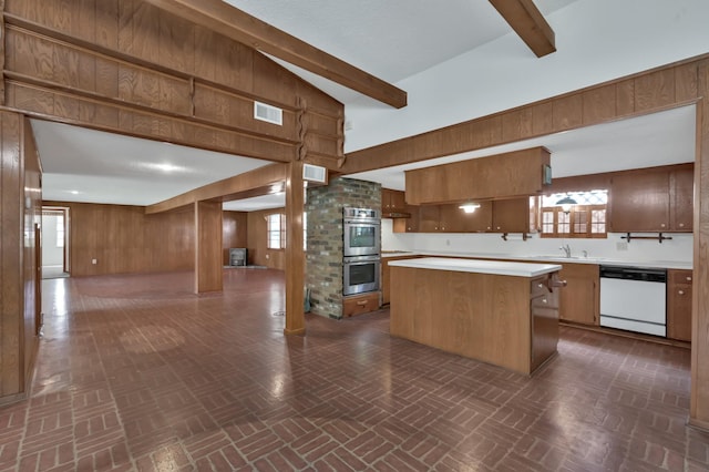 17230 Pioneer Trl, Conroe, TX 77302 - kitchen with dishwasher, double oven, wood walls, brick patterned floors, and light countertops