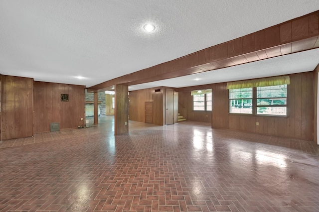 17230 Pioneer Trl, Conroe, TX 77302 - unfurnished living room with wood walls and a textured ceiling