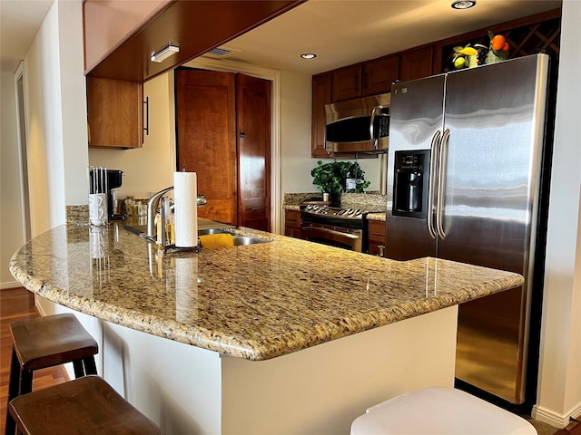 3525 Sage Rd Unit 1502, Houston, TX 77056 - kitchen with stainless steel appliances, a peninsula, recessed lighting, a breakfast bar, and light stone countertops