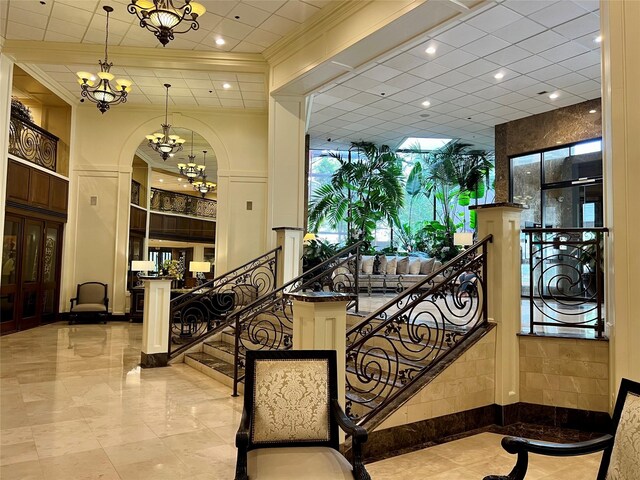 3525 Sage Rd Unit 1502, Houston, TX 77056 - stairway featuring a chandelier, marble tiled flooring, crown molding, recessed lighting, and arched walkways