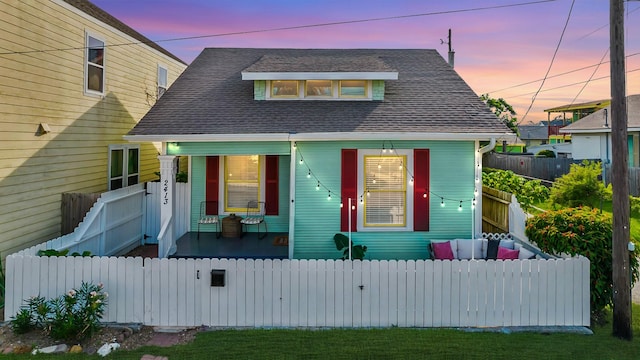 2413 34th St, Galveston, TX 77550 - view of front of home with a porch, a fenced front yard, and a shingled roof